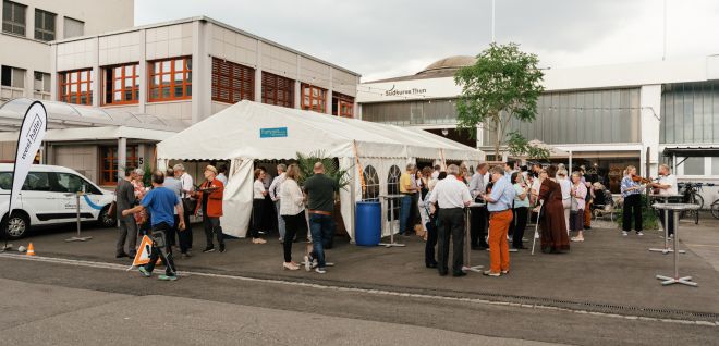 Networking drinks reception in the marquee in front of the industrial building in Thun