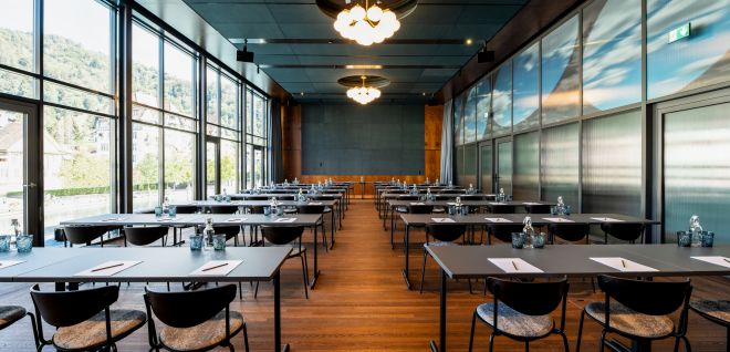 Moderner Seminarraum mit Tischreihen und Panoramafenstern am Thunersee