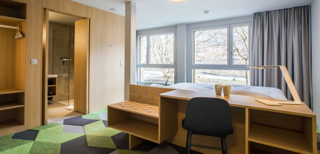 Modernes Hotelzimmer mit Schreibtisch, grossem Fenster und offenem Bad