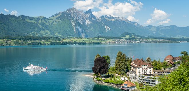 Ausflugsschiff auf dem Thunersee mit Blick auf Berge und Uferpromenade