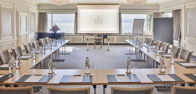 Heller Konferenzraum mit U-Bestuhlung, Leinwand und Seeblick am Thunersee