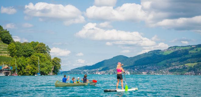 Stand-up-Paddlerin auf dem Thunersee mit Bergen im Hintergrund