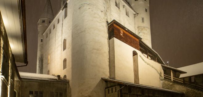 Schloss Thun im Winter bei Nacht mit verschneitem Innenhof und Lichtern