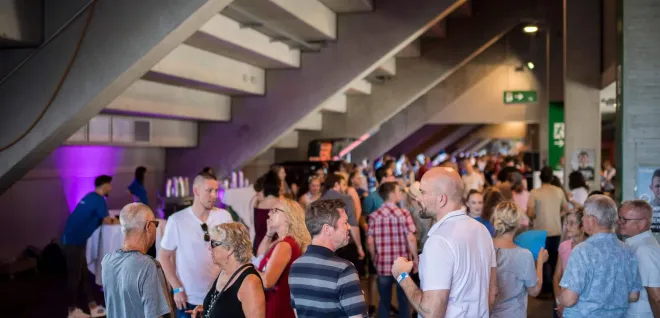 Networking-Event im Foyer mit Gästen unter Treppe