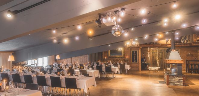 A festively decorated banquet hall with wooden flooring and warm lighting in the Lake Thun region