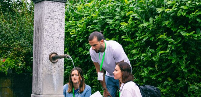 Gruppe am Brunnen bei Outdoor-Event in Thun-Thunersee, mit Notizen und Namensbändern