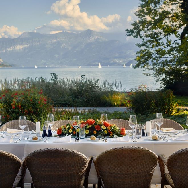 A festively laid table on Lake Thun with views of the Alps and sailing boats