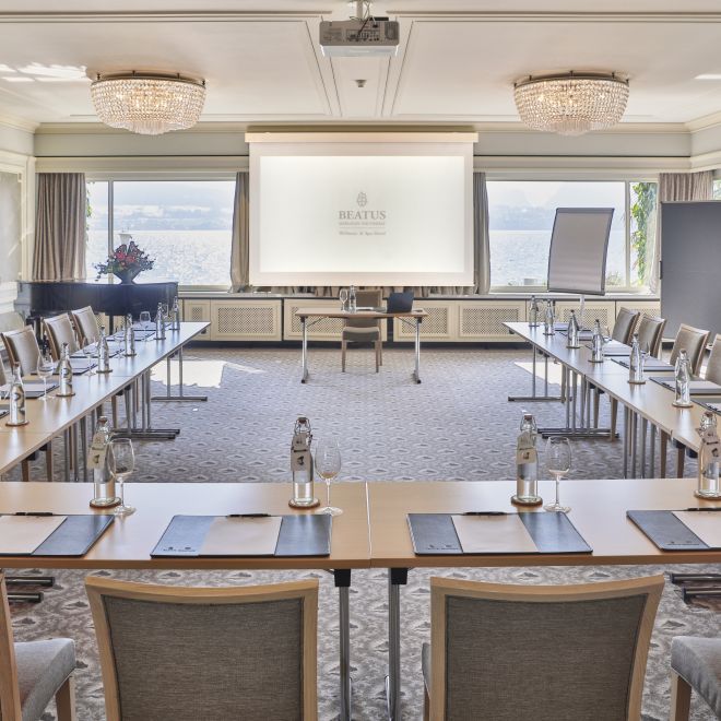 Heller Konferenzraum mit U-Bestuhlung, Leinwand und Seeblick am Thunersee