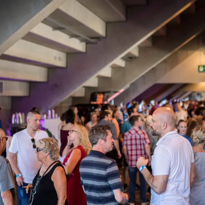 Networking event in the foyer with guests gathered under the stairs