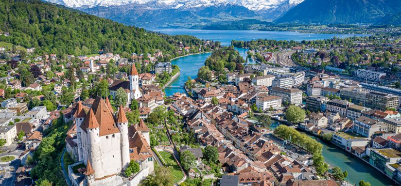 Luftaufnahme von Thun mit Schloss und Alpenpanorama